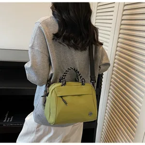 Lightweight green crossbody bag worn by model in a stylish interior setting