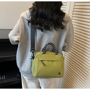 Rear view of model wearing a green nylon crossbody bag with patterned rope handles
