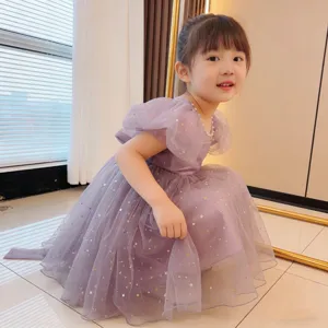 Close-up view of a purple tulle girl dress featuring gold stars and puff sleeves
