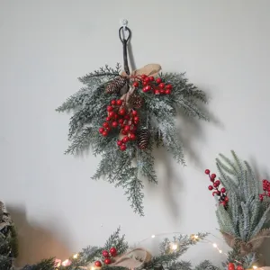 Weihnachtliche Wanddeko mit verschneiten Tannennadeln und roten Beeren
