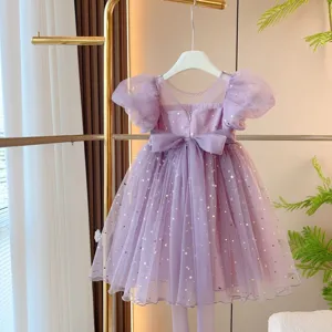 Detailed view of purple girl's mesh dress featuring golden star sequins and bow.