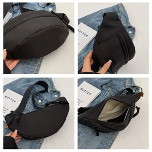 Detailed view of black crescent chest bag showing interior pockets and wide strap