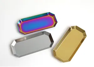 Detail von drei achteckigen Edelstahltabletts in Gold, Silber und Regenbogenfarben.