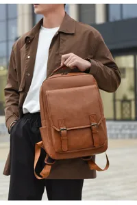 Nahaufnahme eines Mannes, der einen braunen PU-Lederrucksack im Vintage-Stil hält