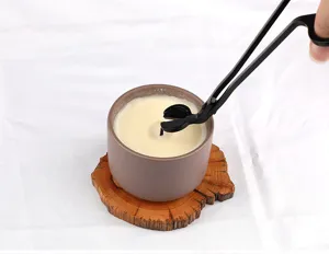 Gros plan d'un coupe-mèche de bougie papillon en acier inoxydable noir mat en action