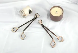 Vue détaillée de deux coupe-mèches en acier inoxydable bronze sur un tissu blanc