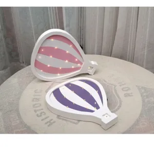 Detailed macro view of wooden hot air balloon LED night lights in pink and purple stripes