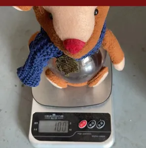 Detailed view of the Christmas reindeer candy jar being weighed on a digital scale showing 100g.