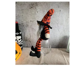 Muñeco gnomo bruja de Halloween de piernas largas sentado en una copa deco
