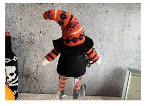 Primer plano de un gnomo bruja de Halloween sin rostro con gorro de punto a rayas.