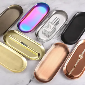 Varietà di vassoi ovali in acciaio inossidabile in finiture metalliche oro e bronzo.