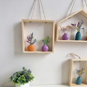 Creatieve houten wandlijsten met kleurrijke minivaasjes en decoratieve droogbloemen.