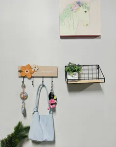 Decorative wooden wall hook rack with floral accents and hanging items in a home scene