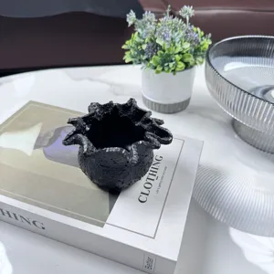 Detailed view of a black textured resin candle holder with unique jagged rim