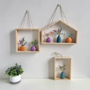 Set van houten wandplanken met kleine kleurrijke vazen en decoratieve droogbloemen