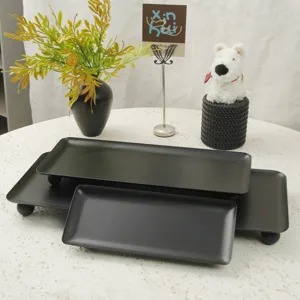 Set of matte black rectangular trays with spherical feet for luxury dessert display