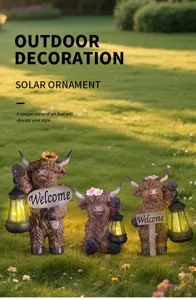 Three Highland cow resin garden statues with solar lanterns in a grassy yard.