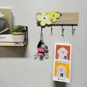 Decorative wall-mounted wood and metal coat hook featuring yellow flowers and beautiful text
