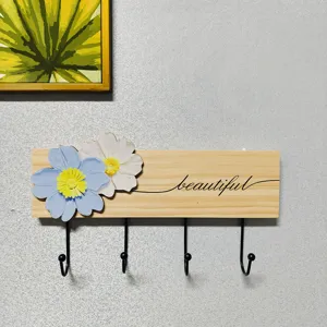 Solid wood wall mounted coat rack with four black metal hooks and cute floral decor for home.