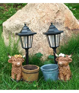 Detail view of decorative solar highland cow garden statues featuring cute flower crowns