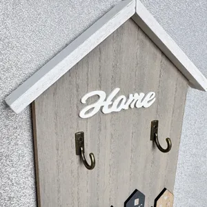 Detail of house-shaped wooden wall hook with 3D white Home lettering decoration