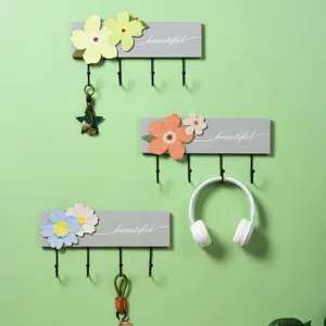 Close-up view of decorative floral wall hooks set against a calming light green backdrop