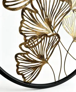 Detailansicht goldener Wanddeko aus Metall mit Ginkgoblattern und schwarzem Rundrahmen
