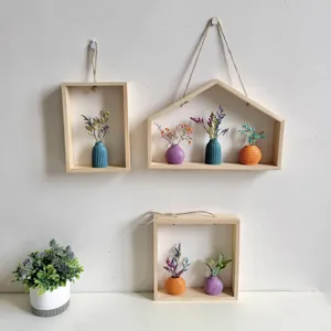 Houten wandframes in INS-stijl met kleurrijke keramieken vazen en droogbloemen