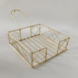 Gold metal napkin holder detail view, iron wire tissue organizer for modern desktop table.