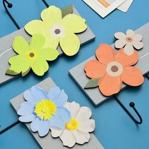 Macro view of colorful floral wall hooks featuring wooden base and black iron hooks