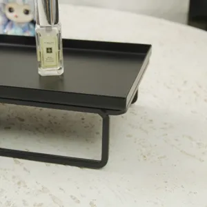 Vista detallada de una bandeja rectangular negra mate con patas altas para postres.