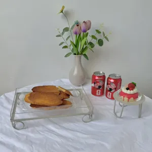 Primer plano de bandeja de acrílico transparente y soporte de metal con dulces en mesa