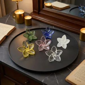 Set of six colorful crystal glass flower ornaments displayed on a minimalist black tray