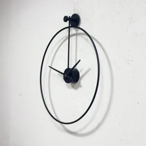 Vista detallada de un reloj de pared minimalista de metal negro con marco circular