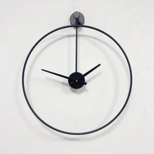 Primer plano de un reloj de pared circular de metal negro con diseño minimalista