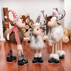 Detail van drie pluchen kerstrendieren met feestelijke gebreide mutsen en sjaals in decor