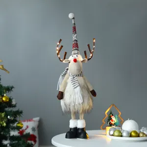 Schattige kerstrendier pluche met LED-verlichte gewei op een feestelijke tafeldecor