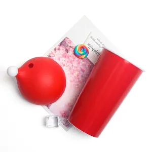 Vista ravvicinata di un bicchiere natalizio in plastica rossa con coperchio a cappello
