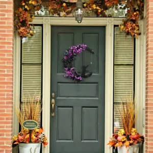 Halloween crescent moon wreath with purple flowers and cat silhouette hanging on a door