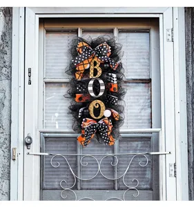 Gros plan d'une couronne d'Halloween noire et orange avec un signe BOO sur une porte