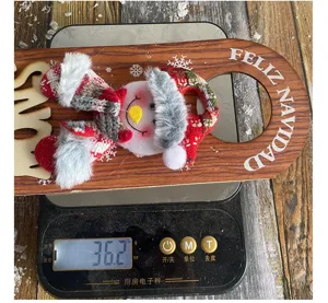 Detail showing a Christmas snowman door handle ornament being weighed on a scale at 36.2g