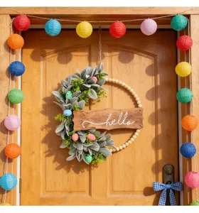 Detailed view of an Easter wreath with a wooden 'hello' sign and colorful speckled eggs