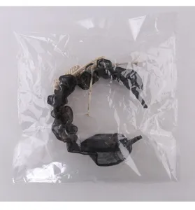 Vue détaillée d'un serre-tête gothique en résille avec crâne dans son emballage plastique