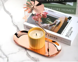 Rose gold carousel candle holder detail, stainless steel tray and aroma candle setup.