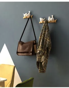 Decorative Nordic bird hooks on branch shown holding a brown bag and a plaid shirt