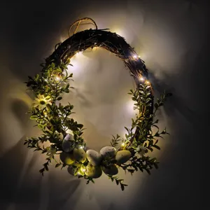 Detail of Easter grapevine wreath with speckled eggs, green leaves, and warm LED lights