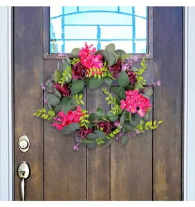 Detailed view of a spring floral wreath with purple roses hanging on a wooden door.