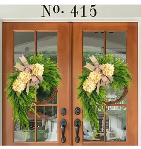 Detail showing artificial hydrangea wreath with burlap bow hanging on wooden front door