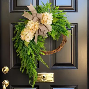 Elegant artificial hydrangea wreath with green foliage and burlap bow for farmhouse door.