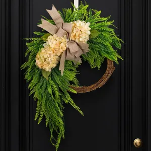Elegant artificial hydrangea wreath with burlap bow for farmhouse style front door decor.